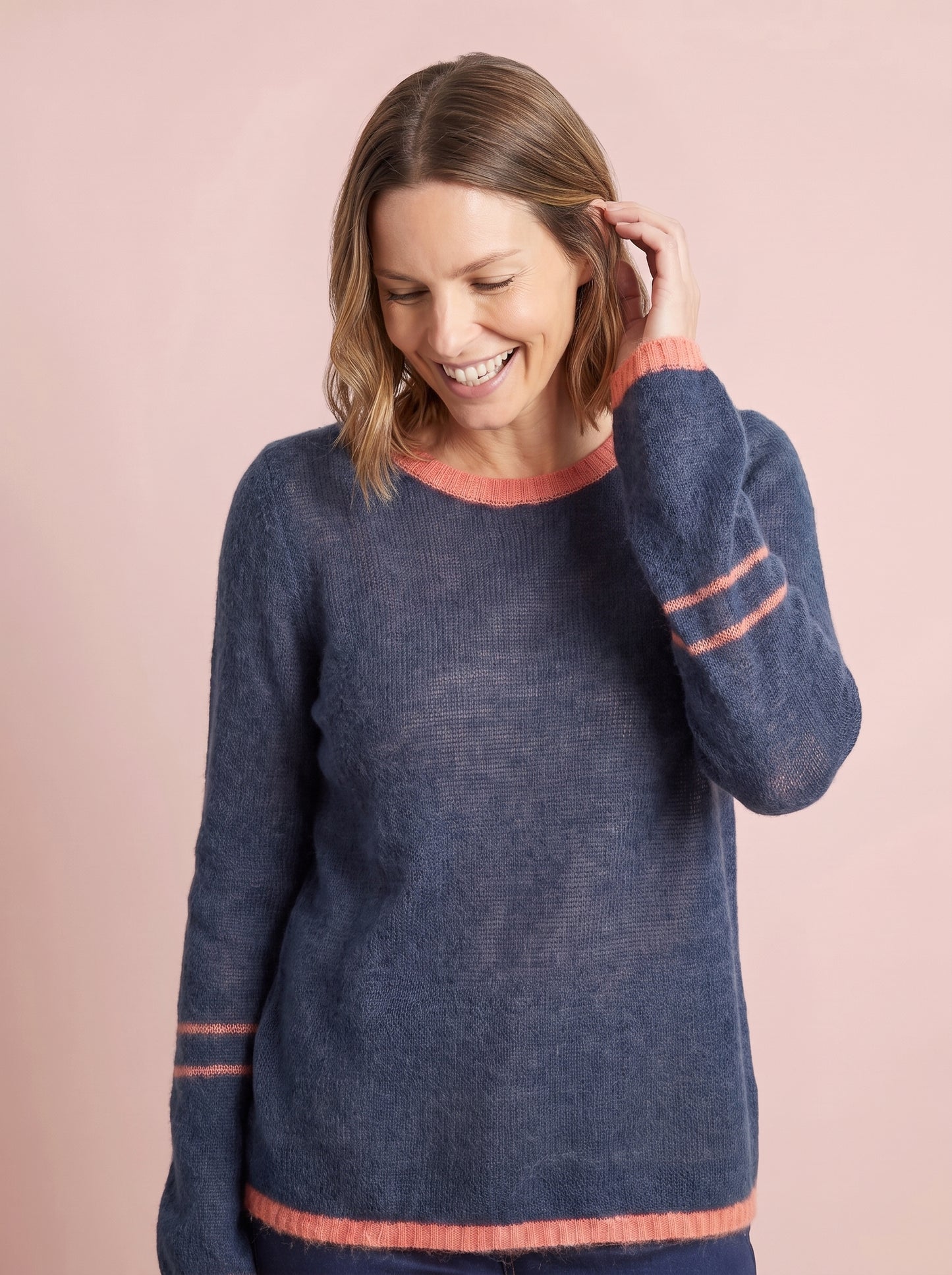 Soft navy blue knit jumper with coral orange ribbed crew neck and hem plus double coral stripe details on the cuffs