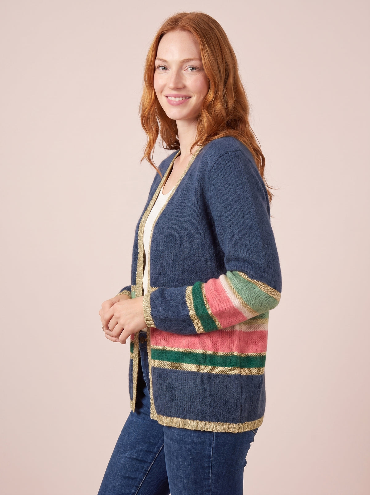 Navy blue knitted cardigan with pink green and gold stripes on the sleeves and hem finished with gold lurex trim and an open front